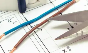Niebieski i brązowy kabel na schemacie elektrycznym. Czy biały kabel to plus czy minus? Nożyce gotowe do cięcia.