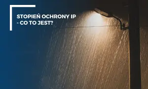 Ulewny deszcz i latarnia uliczna. Tekst: "Stopień ochrony IP - co to jest?". IP 64 oznacza ochronę przed pyłem i bryzgami wody.