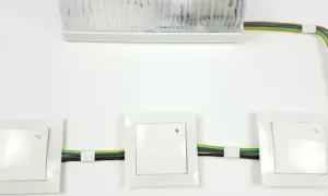 Schemat instalacji elektrycznej: jak podłączyć łącznik krzyżowy. Widoczne trzy łączniki i lampa.