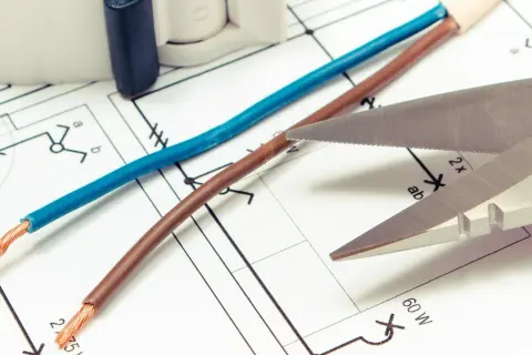Niebieski i brązowy kabel na schemacie elektrycznym. Czy biały kabel to plus czy minus? Nożyce gotowe do cięcia.