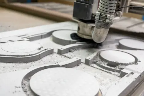 Precyzyjne frezowanie CNC tworzy skomplikowane kształty w materiale. Maszyna usuwa warstwy, tworząc detale.