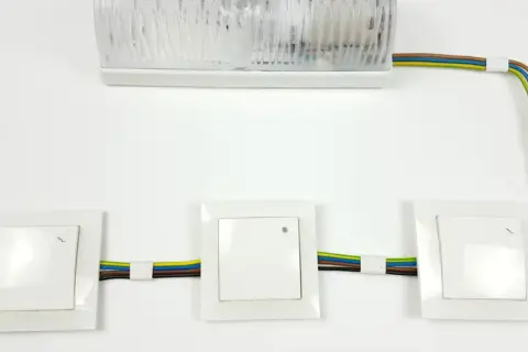 Schemat instalacji elektrycznej: jak podłączyć łącznik krzyżowy. Widoczne trzy łączniki i lampa.