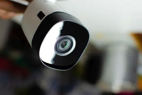 Nowoczesna kamera do monitoringu analogowego, z obiektywem w centrum czarnej ramki.