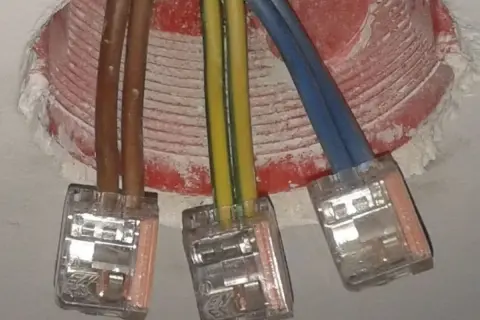 Instalacja elektryczna: brązowe przewody, żółto-zielony i niebieski, połączone w kostkach. Czy faza to plus czy minus?