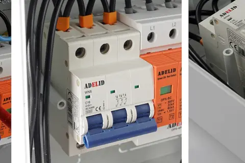 W skrzynce elektrycznej widać bezpieczniki w domu, przewody i wyłączniki.