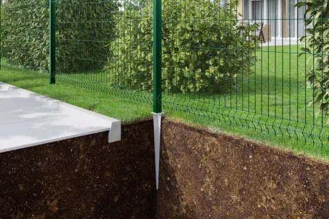 Montaż słupków ogrodzeniowych bez betonu. Metalowy szpic wbity w ziemię, na nim zielony słupek i siatka ogrodzeniowa.