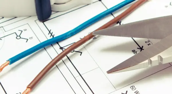 Niebieski i brązowy kabel na schemacie elektrycznym. Czy biały kabel to plus czy minus? Nożyce gotowe do cięcia.