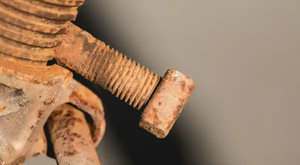 Zardzewiała śruba z gwintem. Aby ją odkręcić, należy ją przekręcić w lewo.