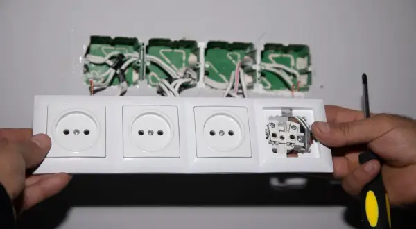 Montaż gniazdek elektrycznych. Widać przewody wychodzące z puszki instalacyjnej i przygotowywane do podłączenia. To pierwszy krok, by dowiedzieć się, jak podłączyć licznik jednofazowy orno.
