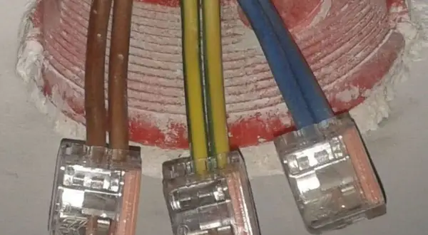 Instalacja elektryczna: brązowe przewody, żółto-zielony i niebieski, połączone w kostkach. Czy faza to plus czy minus?