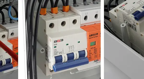 W skrzynce elektrycznej widać bezpieczniki w domu, przewody i wyłączniki.